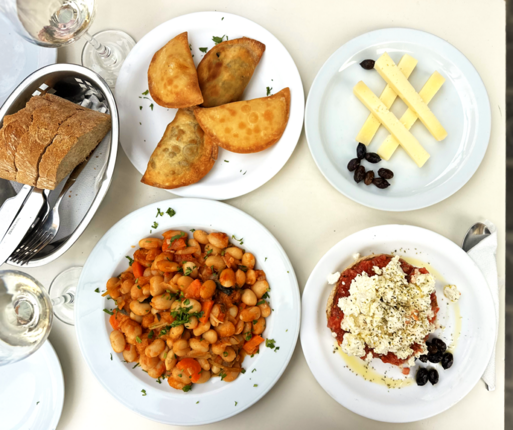 Traditional Cretan meze dishes - kalitsounia, dakos, butter beans and cheese - food tour Chania